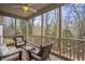 Comfortable screened-in porch with ceiling fan and wicker furniture overlooking a wooded area at 1056 Lukestone Dr, Fuquay Varina, NC 27526