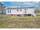 Exterior view of a single-story home with a deck, stairs, and spacious backyard with partial fencing at 110 Hickory Dr, Spring Hope, NC 27882