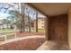 View from a covered balcony overlooking trees, neighboring building, and a sidewalk at 1110 Schaub Dr # B, Raleigh, NC 27606