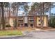 A yellow and brick apartment building with multiple balconies, parking, and tree landscaping at 1110 Schaub Dr # B, Raleigh, NC 27606