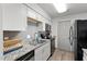 Galley kitchen with stainless steel appliances, granite countertops, gray backsplash, and wood-look floors at 1110 Schaub Dr # B, Raleigh, NC 27606