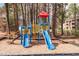 Playground with a blue, yellow, and red playset located near trees and apartment building at 1110 Schaub Dr # B, Raleigh, NC 27606