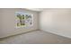 Bright bedroom featuring neutral carpeting, white trim, and a large picture window at 116 Pisgah St, Sanford, NC 27330