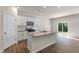 Well-lit kitchen featuring stainless steel appliances, granite countertops, a kitchen island, and sliding glass doors at 116 Pisgah St, Sanford, NC 27330