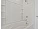 Bathtub and shower with white tiled surround and recessed shelving at 120 Central Townes Way # 292, Raleigh, NC 27603