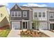 Beautiful townhome with a well-manicured lawn, complemented by a gray and white facade and attached garage at 120 Central Townes Way # 292, Raleigh, NC 27603