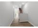 Bright hallway featuring wood-look flooring, white walls, and a staircase leading to the upper level at 120 Central Townes Way # 292, Raleigh, NC 27603