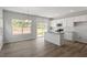 Bright kitchen featuring white cabinets, granite countertops, and wood-look floors, with a view to the outdoors at 120 Central Townes Way # 292, Raleigh, NC 27603