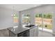 Bright kitchen area with granite countertop island, stainless steel dishwasher, and sliding glass doors at 120 Central Townes Way # 292, Raleigh, NC 27603