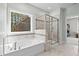 Bright bathroom featuring a soaking tub, glass shower, and natural light from a large window at 126 Filigree Way, Durham, NC 27713