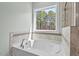 Bright bathroom features a soaking tub, large window, and tiled walls at 126 Filigree Way, Durham, NC 27713