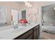 Bathroom with double sink vanity, dark wood cabinetry and access to bedroom at 126 Filigree Way, Durham, NC 27713