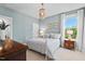 Comfortable bedroom with a white metal bed frame, chandelier, and sun-filled window at 126 Filigree Way, Durham, NC 27713