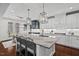 Open kitchen and dining area, featuring dark hardwood floors, island with granite counters, and modern lighting at 126 Filigree Way, Durham, NC 27713