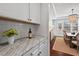 Kitchen area featuring white cabinetry, granite countertops, and views to the dining room at 126 Filigree Way, Durham, NC 27713