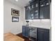Kitchen with blue cabinets, granite countertop, wine cooler, and under cabinet lighting at 126 Filigree Way, Durham, NC 27713