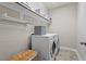 Laundry room with washer, dryer, shelves, baskets, tile floor and neutral walls at 126 Filigree Way, Durham, NC 27713