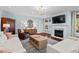 Bright living room with fireplace, large TV, hardwood floors, and neutral-colored furnishings at 126 Filigree Way, Durham, NC 27713