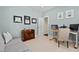 Home office with pale blue walls, work area, and comfortable sitting area with a gray couch at 126 Filigree Way, Durham, NC 27713