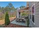 Outdoor patio with table, seating, lighting, grill, with mature trees, and privacy fence at 126 Filigree Way, Durham, NC 27713