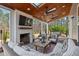 Inviting outdoor living space features a fireplace, comfortable seating, and wooded views at 126 Filigree Way, Durham, NC 27713