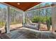 Inviting covered patio featuring a swing bed, stone flooring and wooded backyard view at 126 Filigree Way, Durham, NC 27713