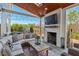 Covered outdoor patio with fireplace, comfortable seating, and string lights for cozy evenings at 126 Filigree Way, Durham, NC 27713