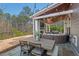 Back patio boasts a wooden table, chairs, and outdoor seating in a wooded backyard at 126 Filigree Way, Durham, NC 27713