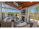 Covered outdoor patio with fireplace, comfortable seating, and string lights for cozy evenings at 126 Filigree Way, Durham, NC 27713