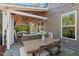 Outdoor dining and seating area with a fireplace, TV, and wooded views at 126 Filigree Way, Durham, NC 27713