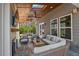 Covered patio boasts an outdoor fireplace, TV, comfortable seating, and outdoor ceiling fans at 126 Filigree Way, Durham, NC 27713
