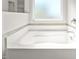 A relaxing white tub is framed by a window with natural light and tile accents at 130 Campaign Dr, Mebane, NC 27302