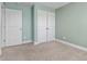 Light and airy bedroom with mint green walls, plush carpeting, and spacious closet at 130 Campaign Dr, Mebane, NC 27302