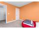 Inviting bedroom with orange accent wall, carpeted floor, and comfy beanbag seating at 130 Campaign Dr, Mebane, NC 27302