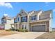 Charming two-story home with stone accents, covered porch, and attached two-car garage at 130 Campaign Dr, Mebane, NC 27302