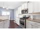 Well-lit kitchen boasting stainless steel appliances, granite counters, and white cabinetry offering a modern cooking space at 130 Campaign Dr, Mebane, NC 27302