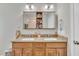 Bathroom boasting a double sink vanity with granite countertops and a large mirror with storage at 130 Hardy Rd, Wendell, NC 27591