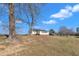Back exterior of home surrounded by a lush green yard, mature trees, and water feature at 130 Hardy Rd, Wendell, NC 27591