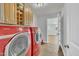 Efficient laundry room featuring modern, red appliances and overhead cabinet storage at 130 Hardy Rd, Wendell, NC 27591