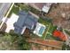 Aerial view of house with pool, sport court, outdoor seating, lush landscaping, and surrounding neighborhood at 1323 Ridge Rd, Raleigh, NC 27607