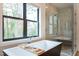 Modern bathroom showcasing a freestanding tub, walk-in shower, and a large window with a scenic view at 1323 Ridge Rd, Raleigh, NC 27607