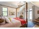 Bright bedroom features a four-poster bed, multiple windows, and an accent chair at 1323 Ridge Rd, Raleigh, NC 27607
