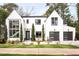 Striking modern home featuring a white facade, black framed windows, and well-kept landscaping at 1323 Ridge Rd, Raleigh, NC 27607