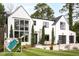 Stunning modern home with crisp white exterior, black trim, and beautifully manicured lawn at 1323 Ridge Rd, Raleigh, NC 27607