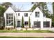 Elegant modern home showcasing a manicured lawn, a symmetrical façade, and a three-car garage at 1323 Ridge Rd, Raleigh, NC 27607