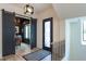 Bright hallway with black framed glass door and a view of the office with modern light fixture at 1323 Ridge Rd, Raleigh, NC 27607