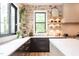 Bright kitchen featuring white countertops, modern finishes, sleek black cabinets, and stone accent wall at 1323 Ridge Rd, Raleigh, NC 27607