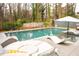 A luxury pool area features stylish white lounge furniture, mature trees, and a relaxing atmosphere at 1323 Ridge Rd, Raleigh, NC 27607