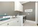 Functional laundry room with white cabinets, sink, and modern washer/dryer at 1327 Gloriosa St, Apex, NC 27523
