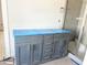 Bathroom vanity with a gray cabinet, drawers, and a tiled shower at 1448B Maplewood Dr, Durham, NC 27704